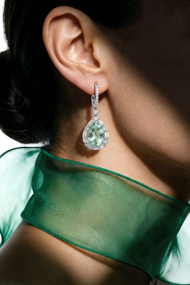 Close-up of a person wearing a green gemstone earring with a green scarf.