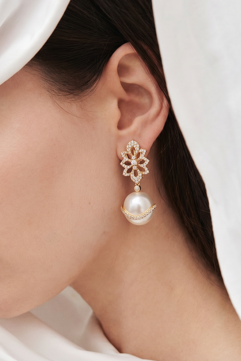 Close-up of a woman wearing pearl earrings with a white headscarf.
