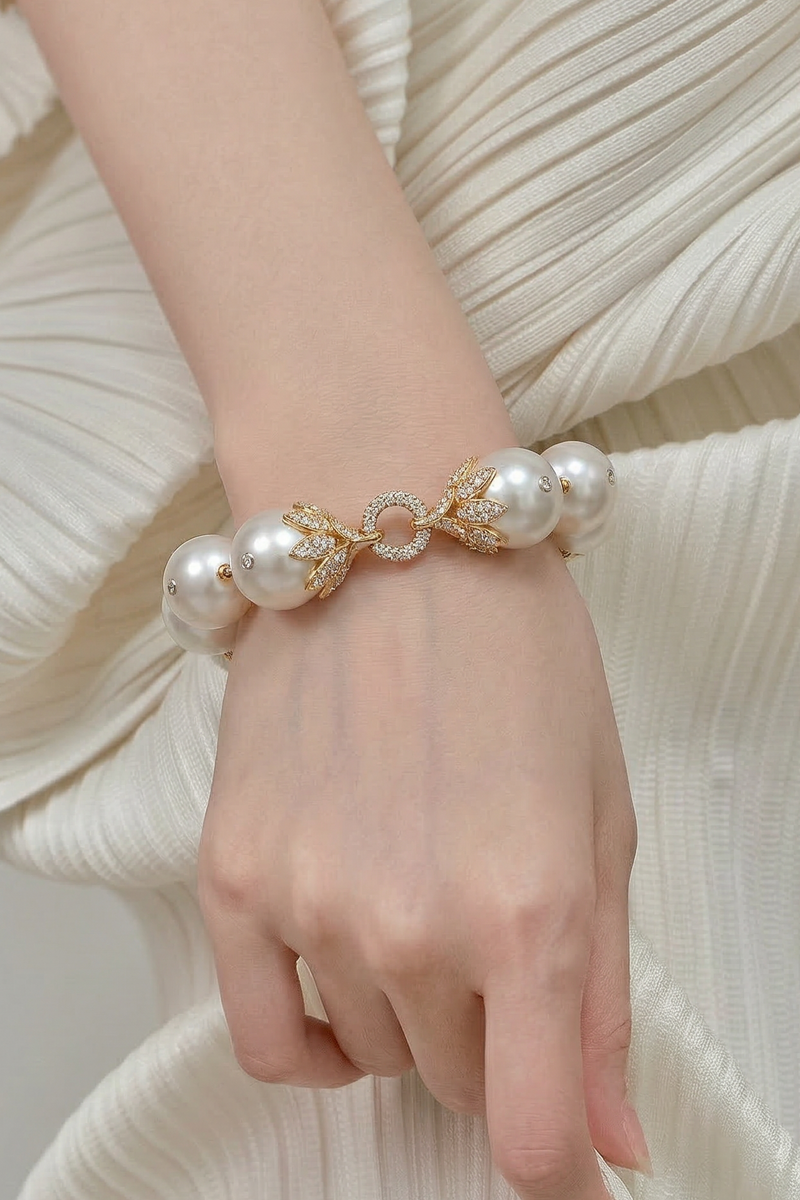 Hand wearing a pearl bracelet with a plain background